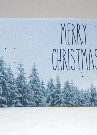Festive greeting card with snowy trees and 'Merry Christmas' text on a light blue background.