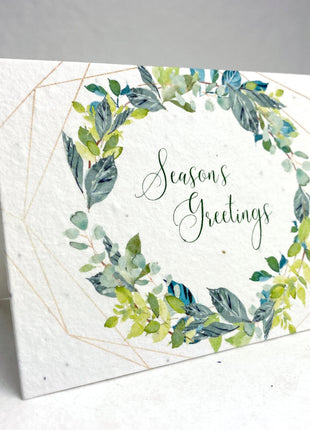 Greeting card with leaf design and 'Seasons Greetings' text on a white background