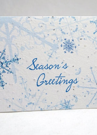 Holiday card with blue snowflakes and 'Season's Greetings' text on a light gray background