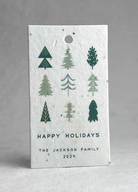Seed paper holiday tag with tree designs and 'Happy Holidays' text on a white background