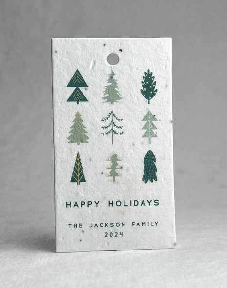 Seed paper holiday tag with tree designs and 'Happy Holidays' text on a white background